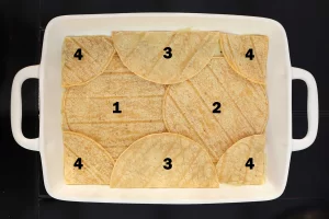 Baking dish with the tortillas laid out in a layer. The tortillas are numbered to show how they should line up.